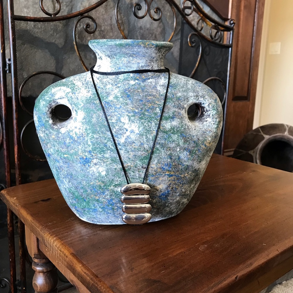 Black adjustable band with a beautiful silver ribbed pendant.